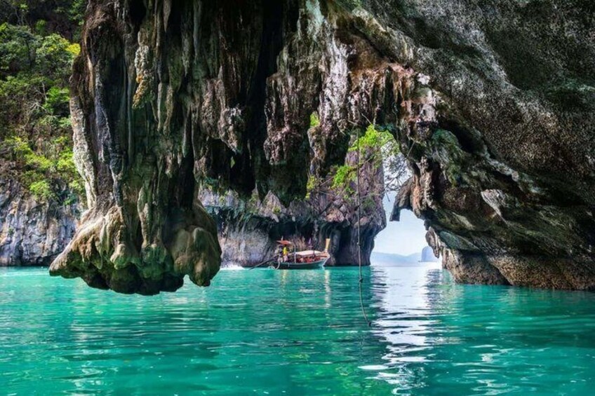 A boat anchored in a cave with turquoise water. 4