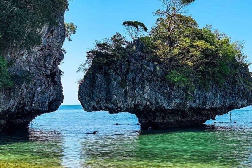 A natural rock formation with clear water in the foreground. 5
