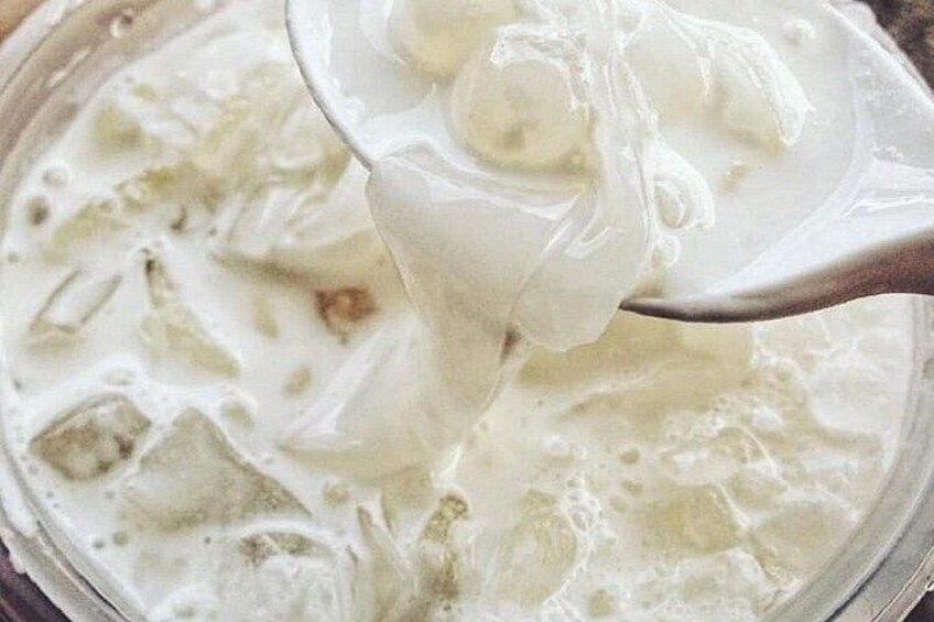 A spoon lifting a creamy substance with visible chunks, possibly a dessert or soup. 3