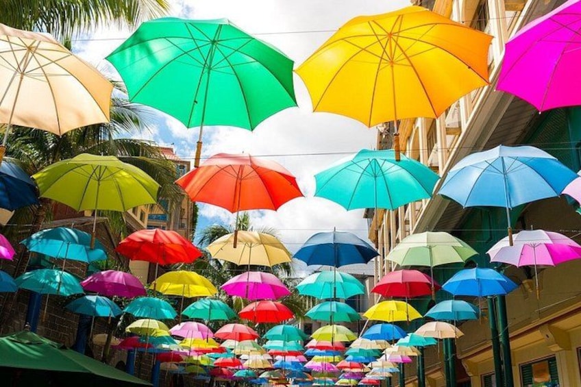 Una strada con ombrelli colorati appesi sopra. 1