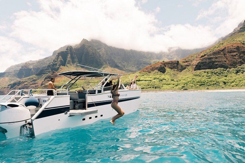 A boat with people on it, water, and mountains in the background. 2