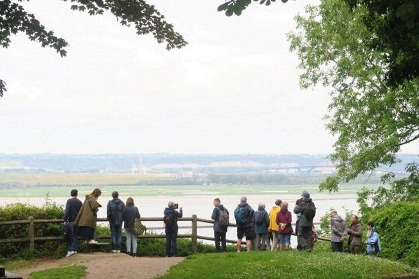 En gruppe mennesker står ved flodbredden og ser ud over floden og det fjerne landskab. 2