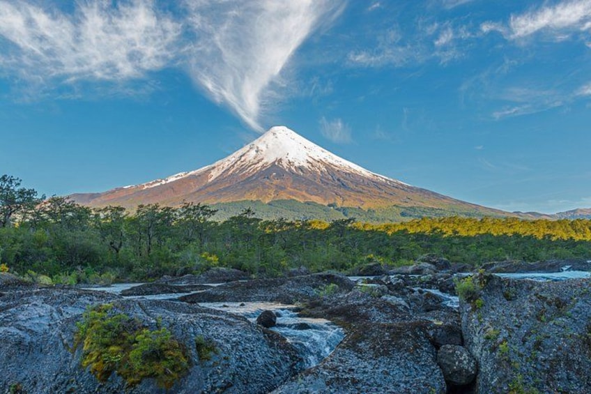 A snow-capped mountain, a river, and a forested area. 1