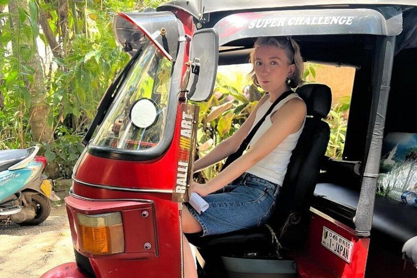 En person sidder i en rød rickshaw med japanske nummerplader. 2