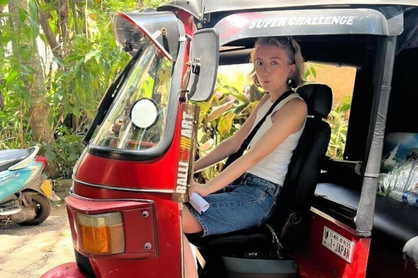 A person sitting in a red auto-rickshaw with 'SUPER CHALLENGE' written on the side. 2