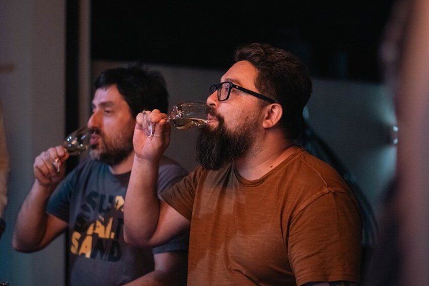 Two people holding wine glasses, likely tasting wine. 2