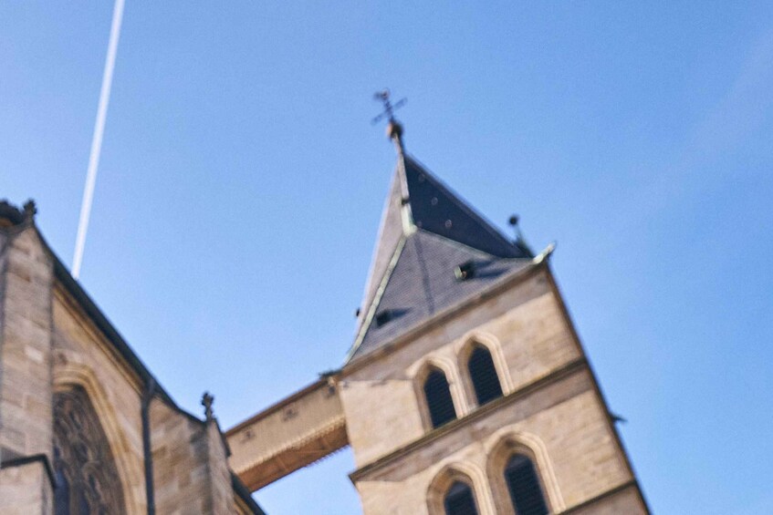 A church tower with a pointed roof and a weather vane. 3