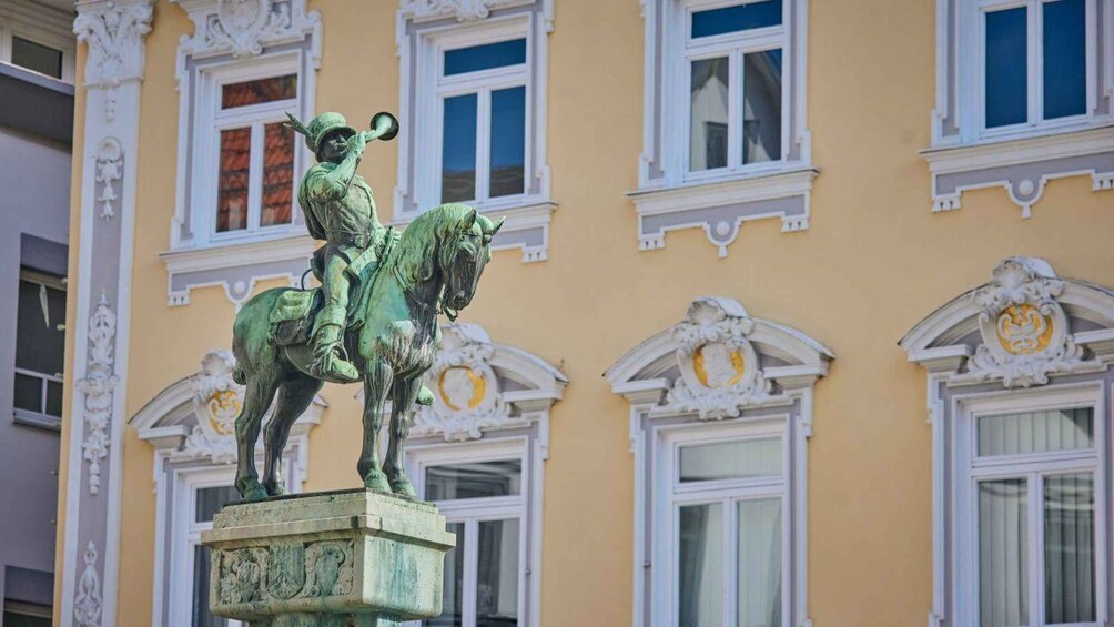 A statue of a man on horseback in front of a building with ornate windows. 2