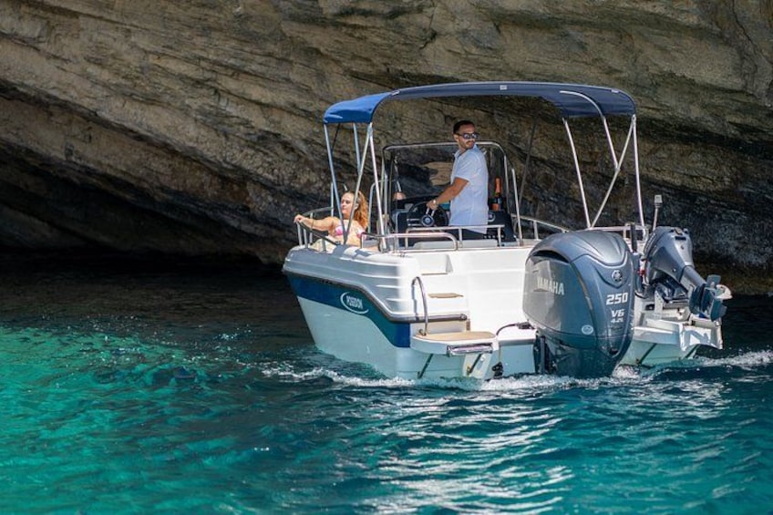 A boat with a canopy, two people, and a rocky background. 4