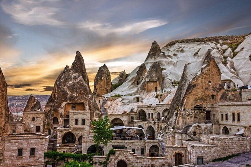 A village with unique conical-roofed buildings nestled among snow-capped mountains. 2