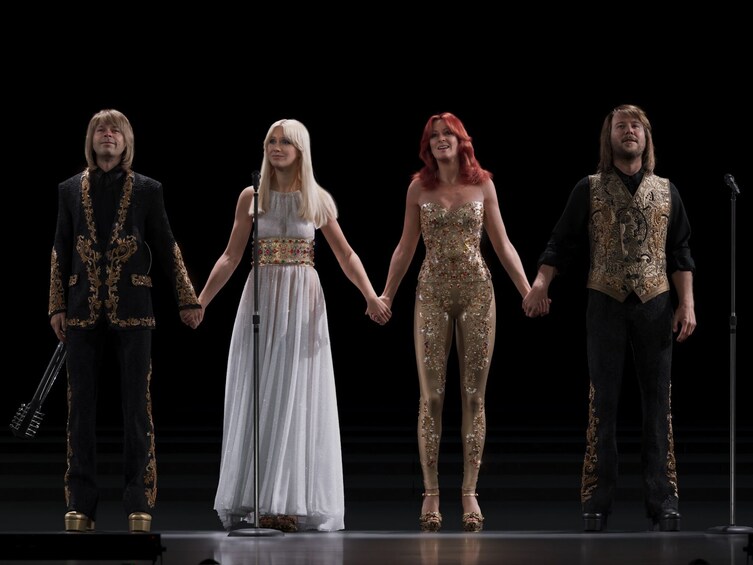 Four people holding hands on a stage. 3