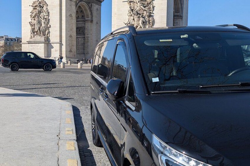 En sort SUV parkeret foran en stor, udsmykket bygning med statuer. 5