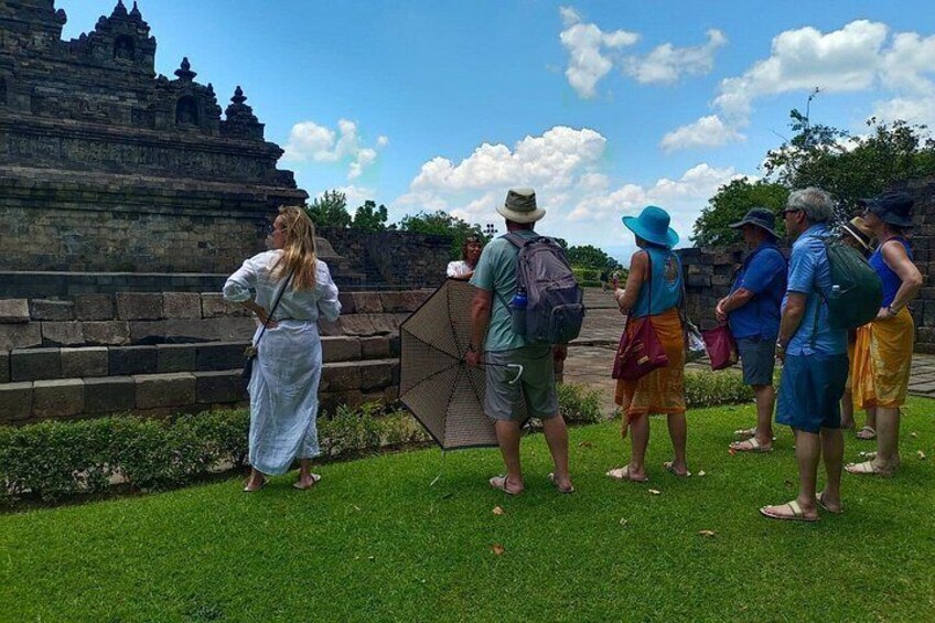 Un grupo de personas de pie sobre césped frente a una estructura tipo templo. 4