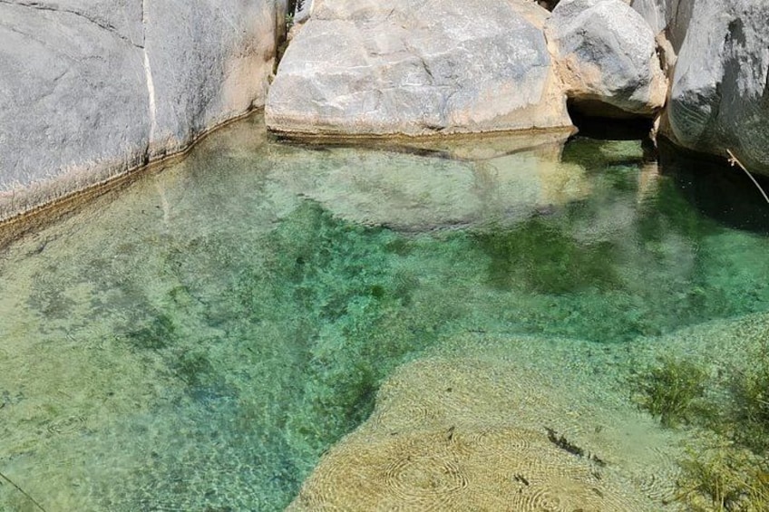 Una piscina cristalina rodeada de grandes rocas. 3