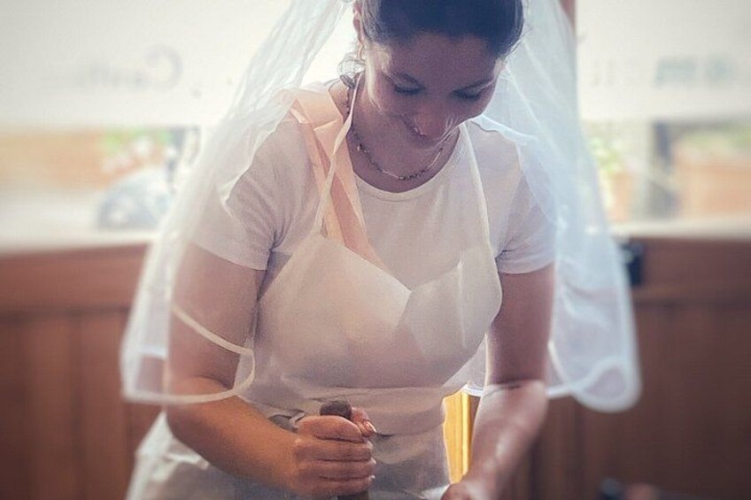 A person in a white shirt and apron, possibly preparing food or working in a kitchen. 2