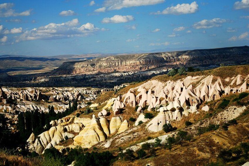 A landscape with prominent white rock formations and a distant city skyline. 2