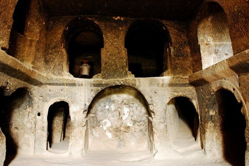 An ancient stone structure with arched openings and a central dome. 3