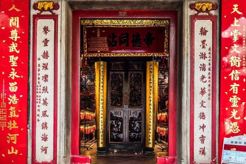 Ein traditioneller chinesischer Tempelaufgang mit aufwendiger Dekoration und roten Wimpeln. 4