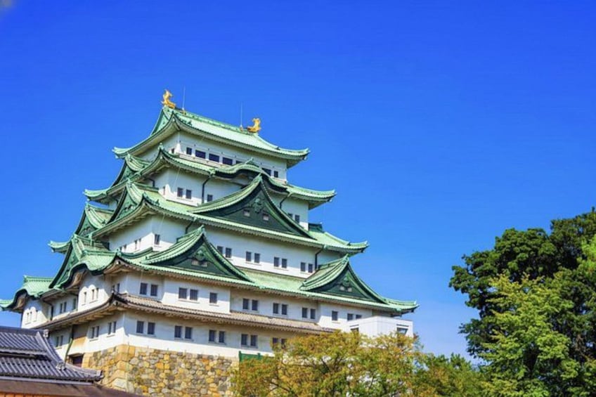 A traditional Japanese castle with multiple tiers and green roofs. 4