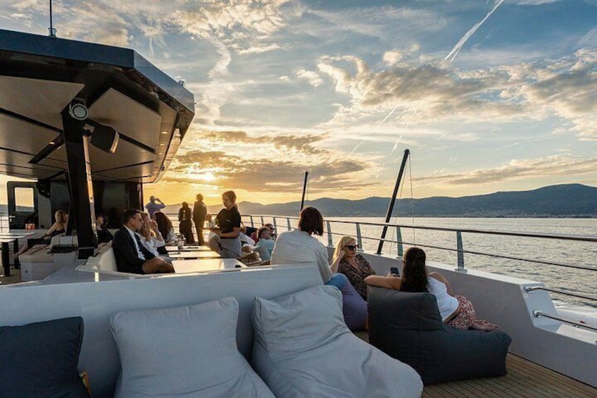 Un coucher de soleil sur un bateau, avec des personnes se détendant sur le pont. 4