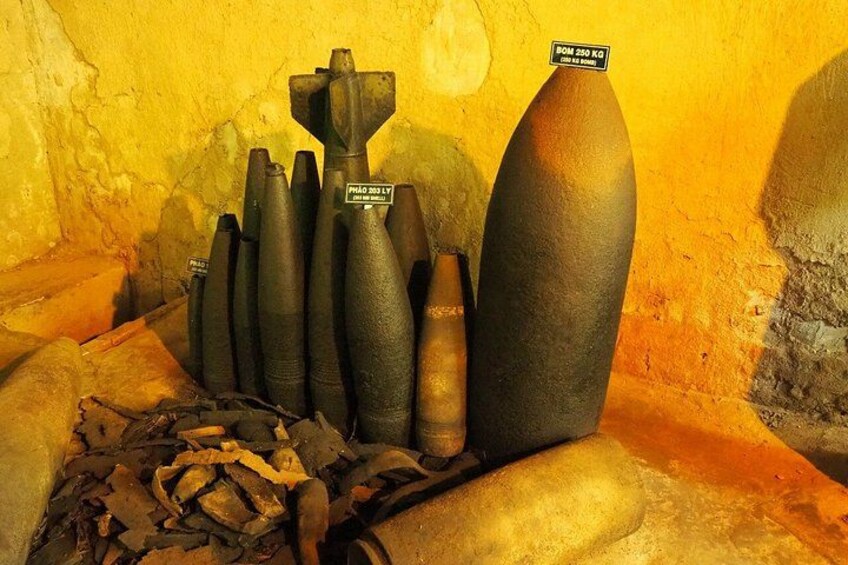 Eine Sammlung von militärischem Kriegsmaterial, darunter Mörser und Bomben, in einem gelb gestrichenen Raum. 5