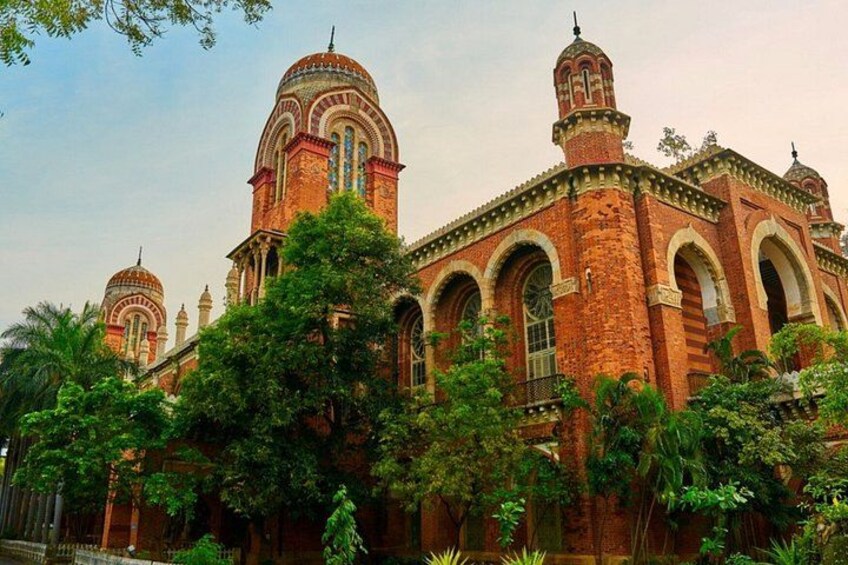 A large, ornate building with multiple domes and arched windows, surrounded by lush greenery. 4
