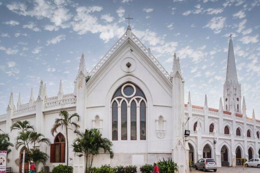 A white church with a pointed steeple and a large arched window. 2