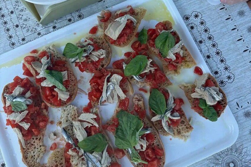 Een schaal bruschetta belegd met tomaten, basilicum en ansjovis. 4
