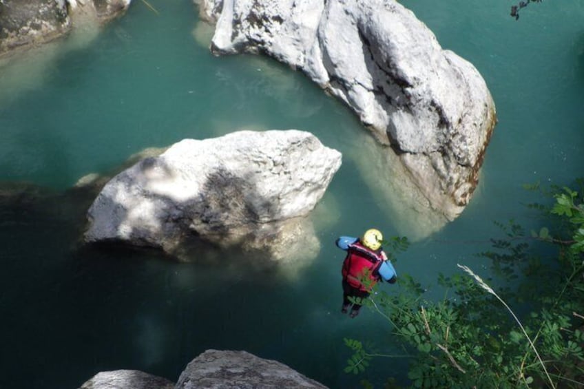 Eine Person springt mit einem Bungee-Seil von einer Klippe in einen Fluss. 1