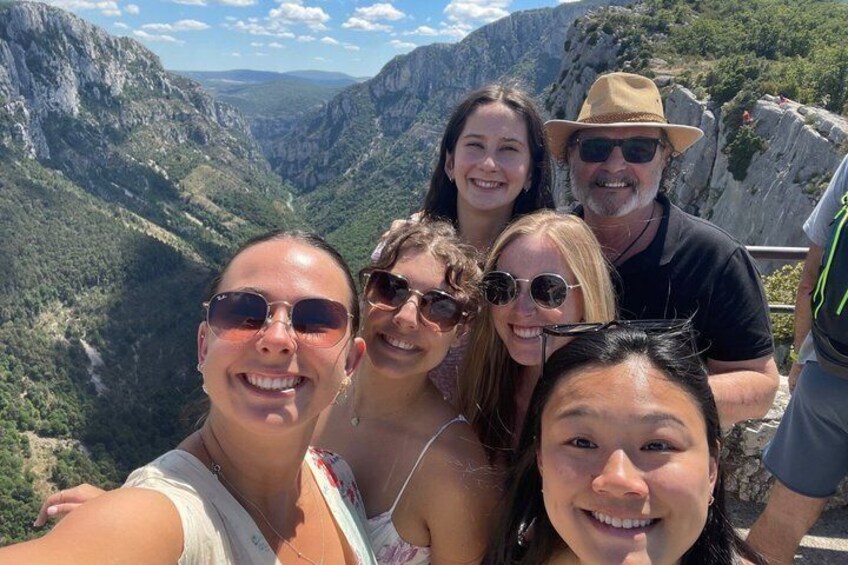 Eine Gruppe von Menschen macht ein Selfie vor einer bergigen Landschaft. 3