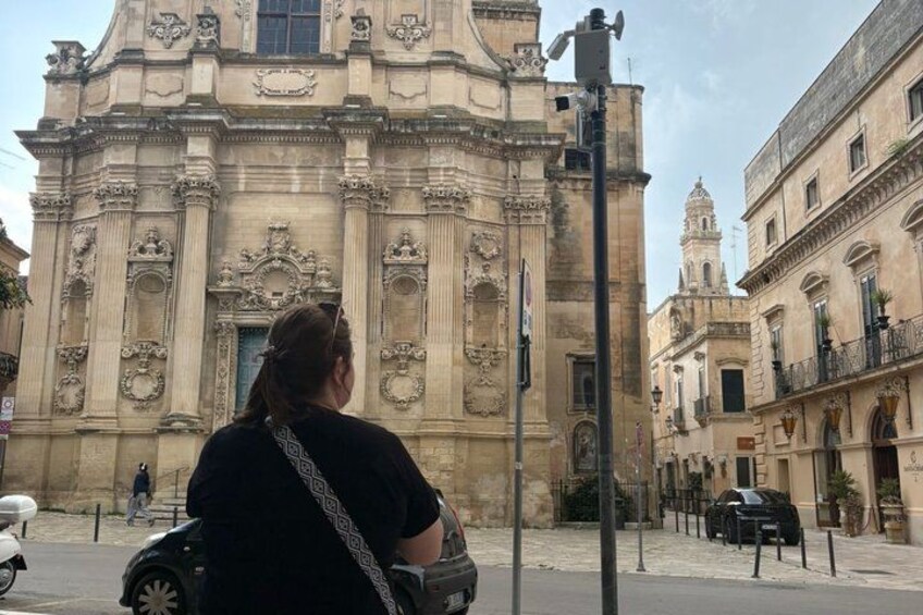 A woman standing in front of a historic building with ornate architecture. 2