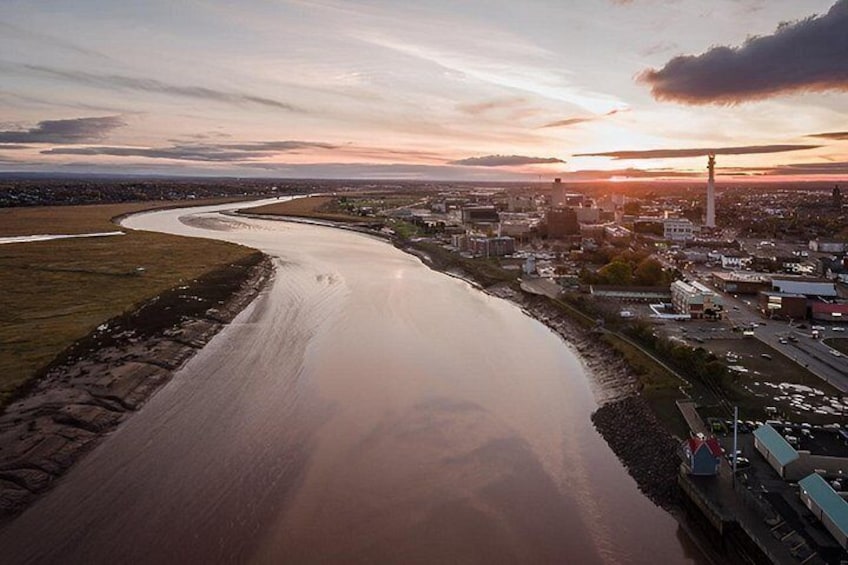 A river curving through a city with buildings and a lighthouse. 3