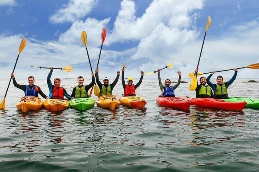 Un groupe de personnes pratiquant le kayak sur une étendue d’eau sous un ciel dégagé. 5