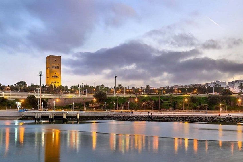Una banchina con una torre, un ponte e uno skyline urbano sotto un cielo nuvoloso. 4