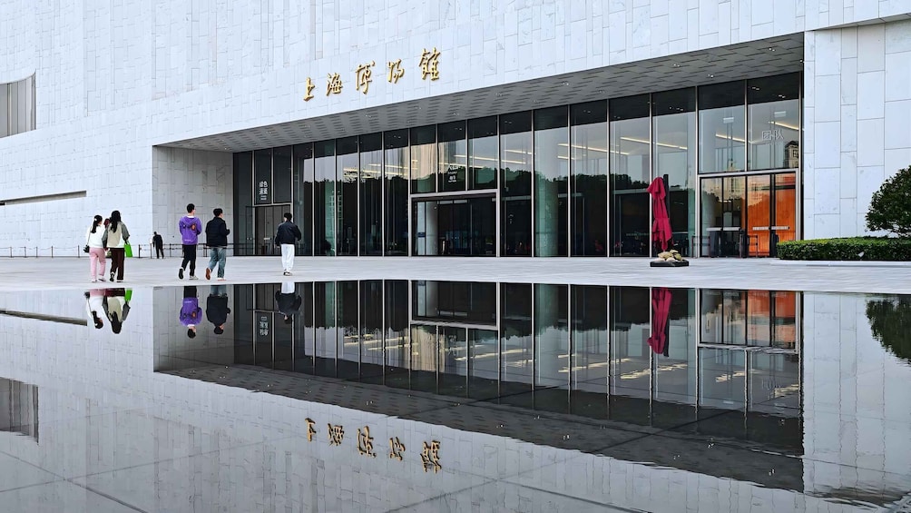A modern building with reflective glass windows and a clear reflection in the water. 1