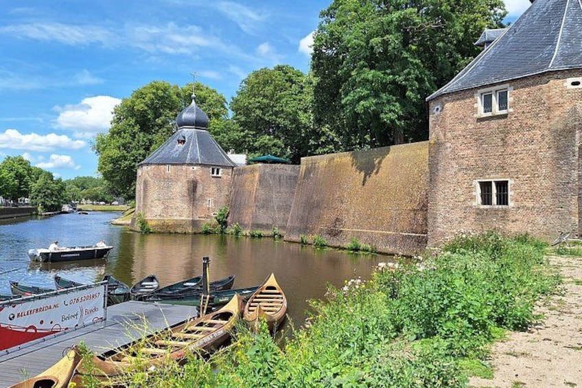 A canal with boats, a brick building, and a tower. 3