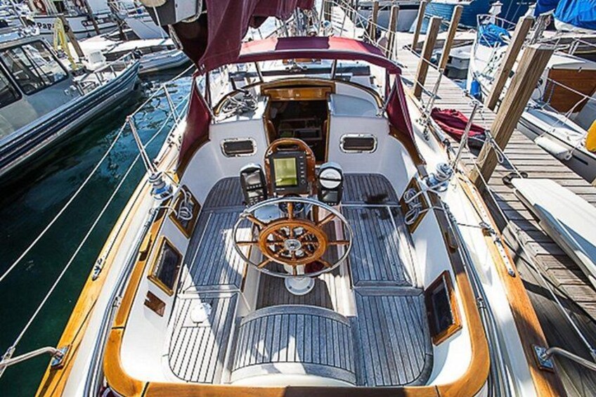Ein Bootsdeck mit Steuer, Tischen und Stühlen. 2