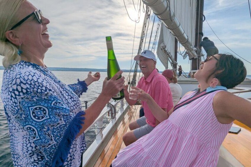 A sailboat with people toasting with champagne. 1