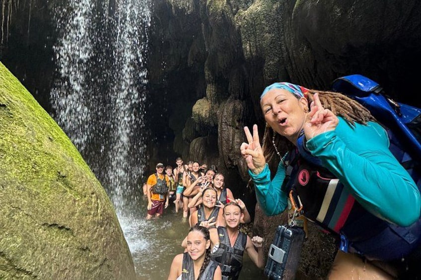 A group of people in a cave with a waterfall. 1