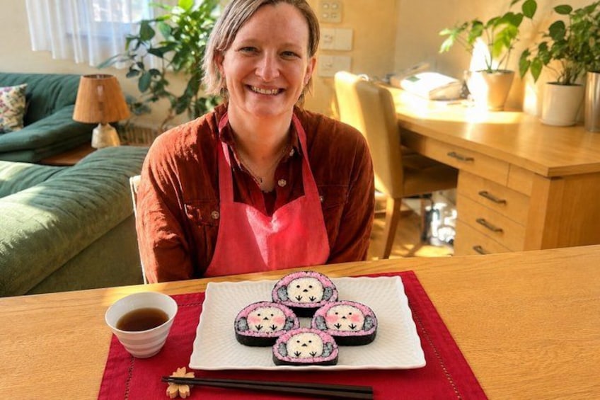 A person sitting at a table with a plate of sushi, a cup of tea, and chopsticks. 3
