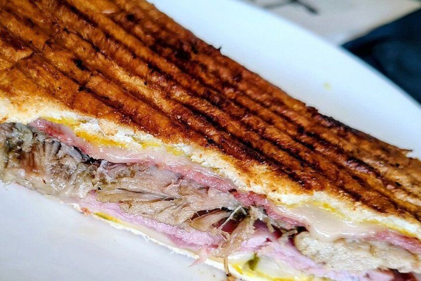 Un sándwich a la parrilla con capas visibles de carne y queso. 3
