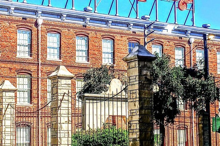 Un bâtiment en briques doté de nombreuses fenêtres et d’un portail en pierre. 2