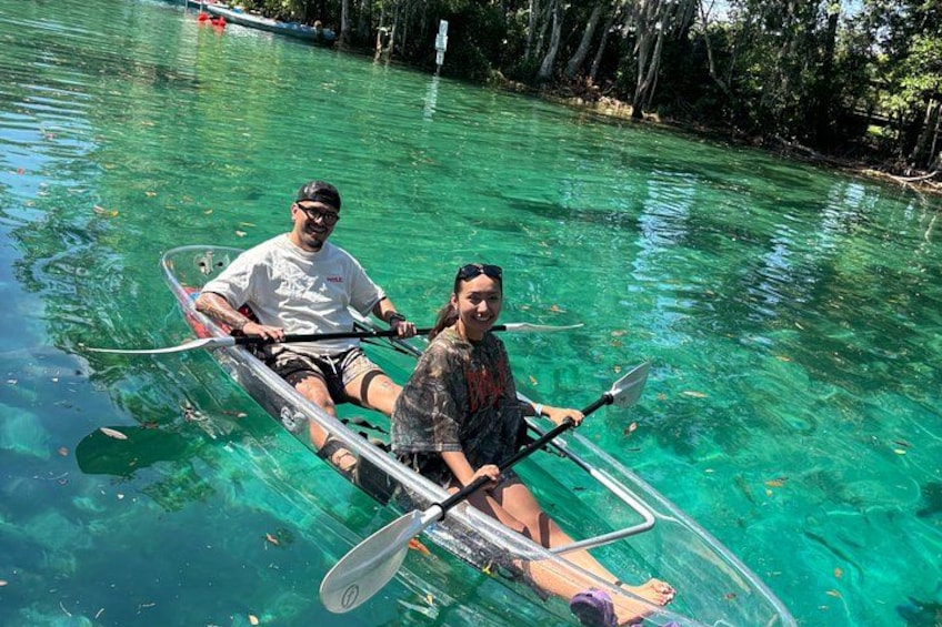 Dos personas en un kayak transparente sobre aguas claras. 2
