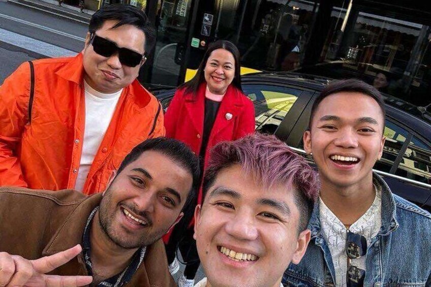 A group of people posing for a photo on a city street. 5