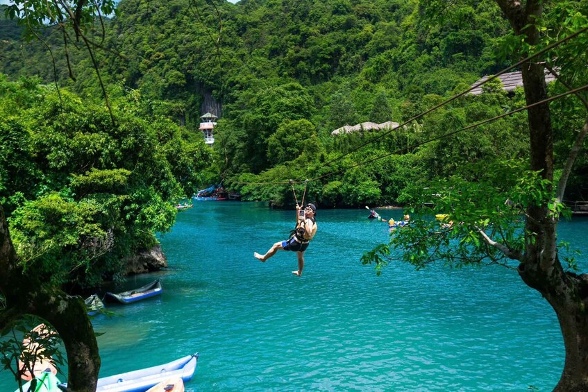 A person swinging on a rope over a river surrounded by dense forest. 2