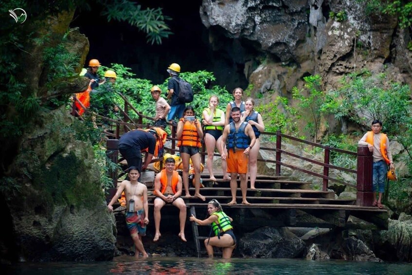 A group of people on a wooden staircase in a rocky, forested area. 3