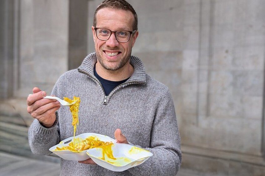 Una persona che tiene un piatto con avanzi di cibo e un cucchiaio. 1