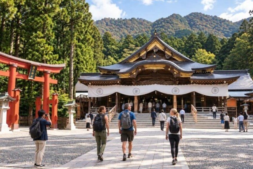 A traditional Japanese temple with a red torii gate, surrounded by lush greenery and mountains. 5