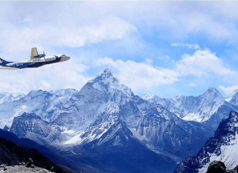A commercial airplane flying over snow-capped mountains. 1