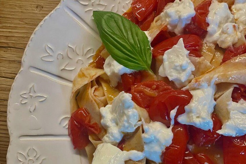 A plate of food with tomatoes, cheese, and a basil leaf. 4